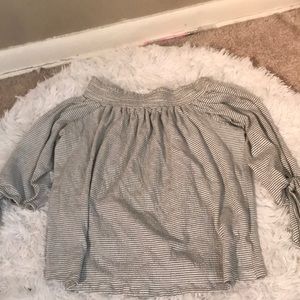 A white and black crop top shows shoulder.